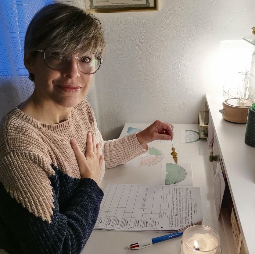 Laetitia TRY, énergéticienne à Pins-Justaret, réalisant un soin énergétique à distance à l’aide d’un pendule de radiesthésie